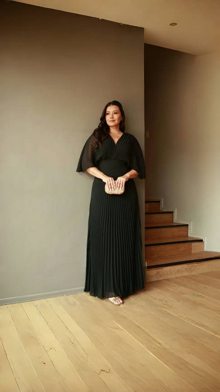 Black pleated maxi dress with V-neck and batwing sleeves, full-length skirt