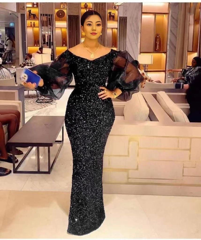 Black sequin maxi dress with sheer puff sleeves and fitted column silhouette