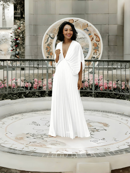 White pleated maxi dress with V-neck and batwing sleeves, flowing full skirt