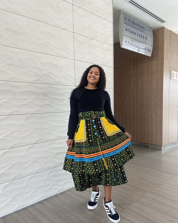 Layered three-piece skirt set with dark top and green patterned tiered skirt with yellow trim