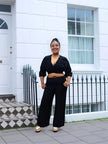 Black V-neck cropped top with ruched bust and wide-leg pants, standing full-body