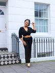 Black V-neck cropped top with ruched bust and wide-leg pants, three-quarter view