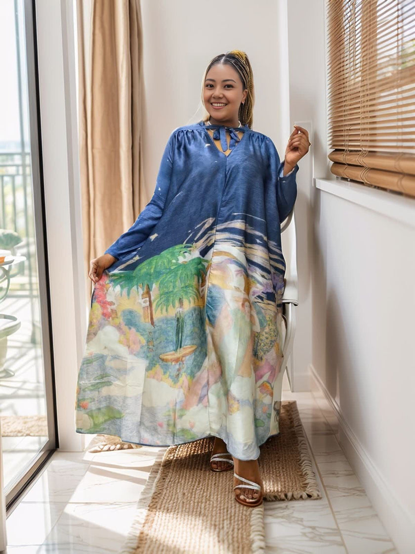 Loose-fit maxi dress with blue long sleeves, V-neck, and tropical print hem panel