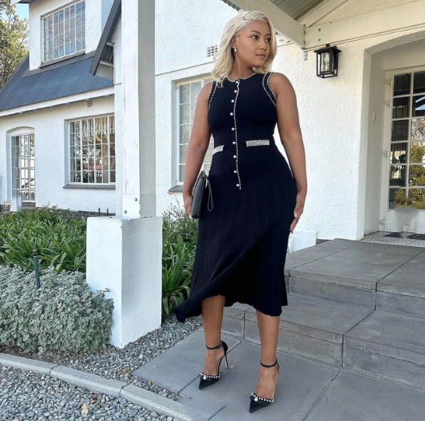 Black sleeveless knitted midi dress with decorative button trim along center front