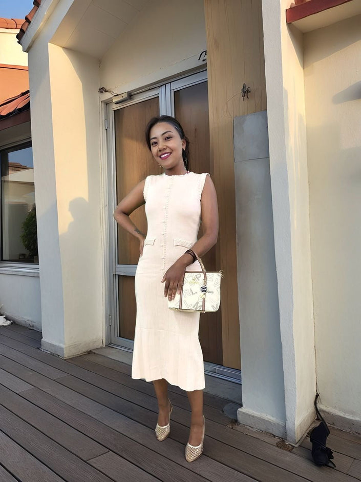 Cream sleeveless knitted midi dress with decorative button front and fitted waist