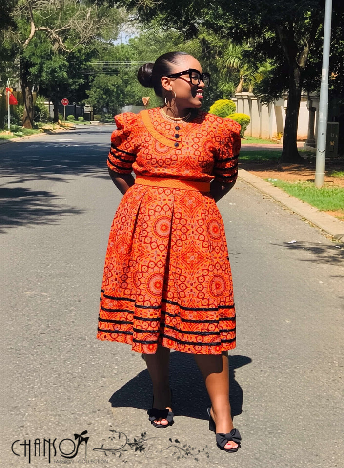 Orange midi dress with puff sleeves and geometric circle print, side view