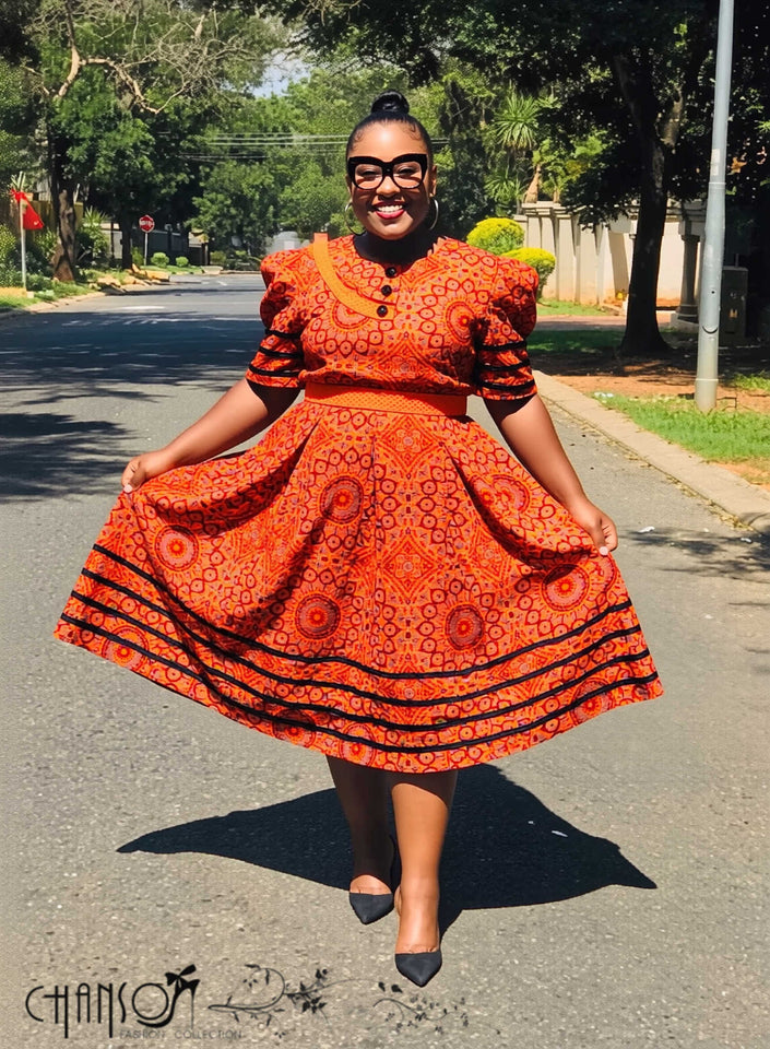 Orange midi dress with puff sleeves and geometric circle print, pleated skirt