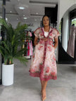 Model wearing belted pink floral midi women's two piece set in a South African fashion retail store