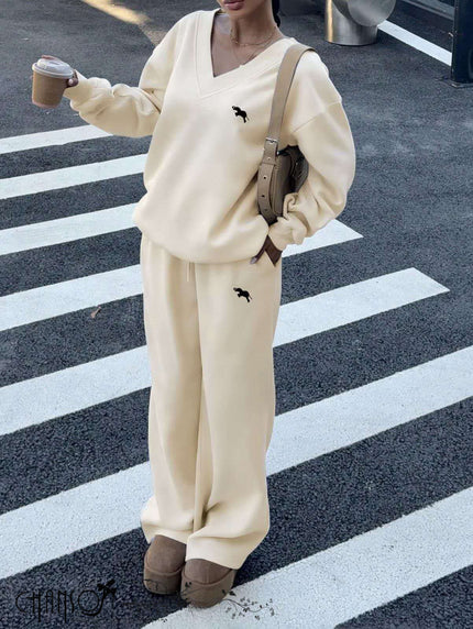 Cream V-neck twin set with dog embroidery: sweatshirt top and wide-leg pants.