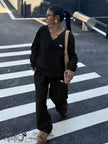 Black V-neck twin set: embroidered sweatshirt top and wide-leg pants.