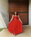 Red maxi dress with floral cutout waist, sleeveless bodice, pleated full skirt