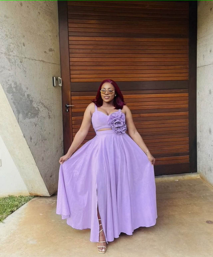Light purple sleeveless maxi dress with rosette floral appliqué at waist and gathered skirt