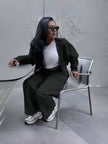 Black zip jacket and tapered pants loungewear set, seated