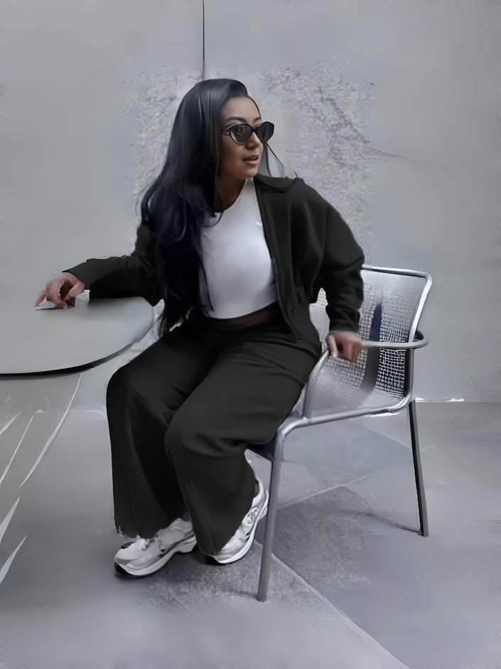Black zip jacket and tapered pants loungewear set, seated