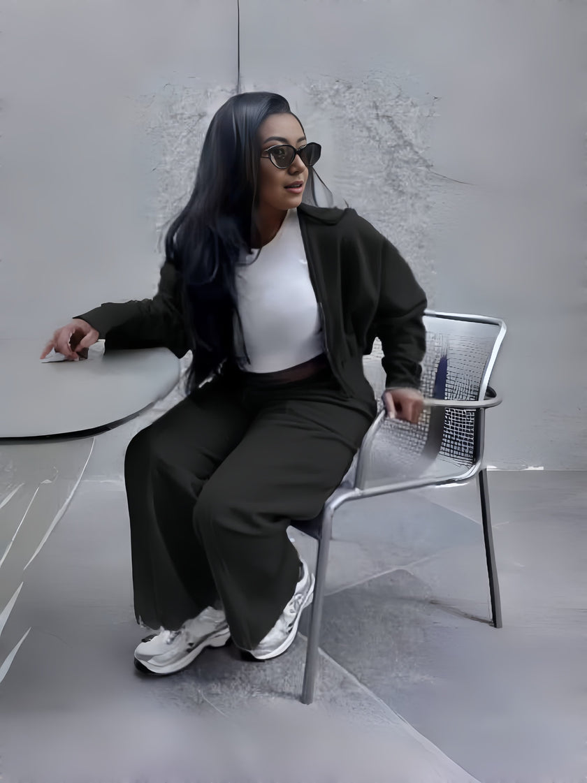 Black zip jacket and tapered pants loungewear set, seated