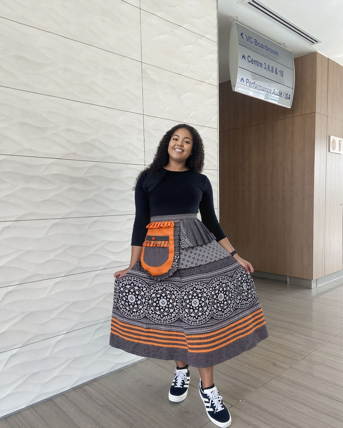 High-waist printed skirt, black-and-cream with paisley medallions and orange border