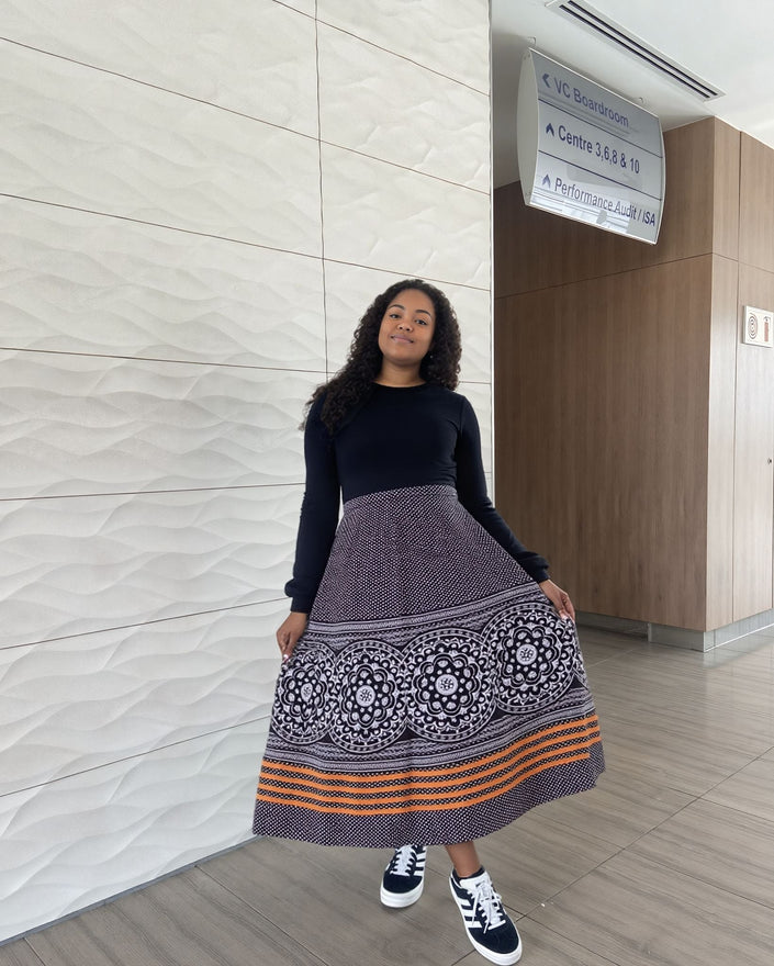 High-waist printed skirt, dark purple with paisley medallions and orange stripe hem