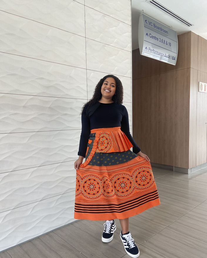 High-waist printed skirt, orange-red with circular motifs and stripe border