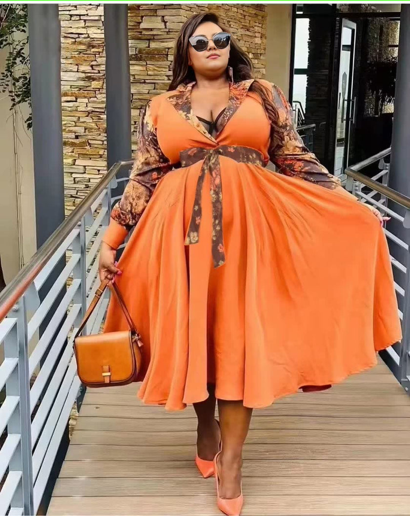 Plus size maxi dress in orange with V-neckline and waist tie detail, flared skirt