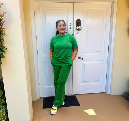 Green wide-leg stretch waist pants with small red logo on thigh.