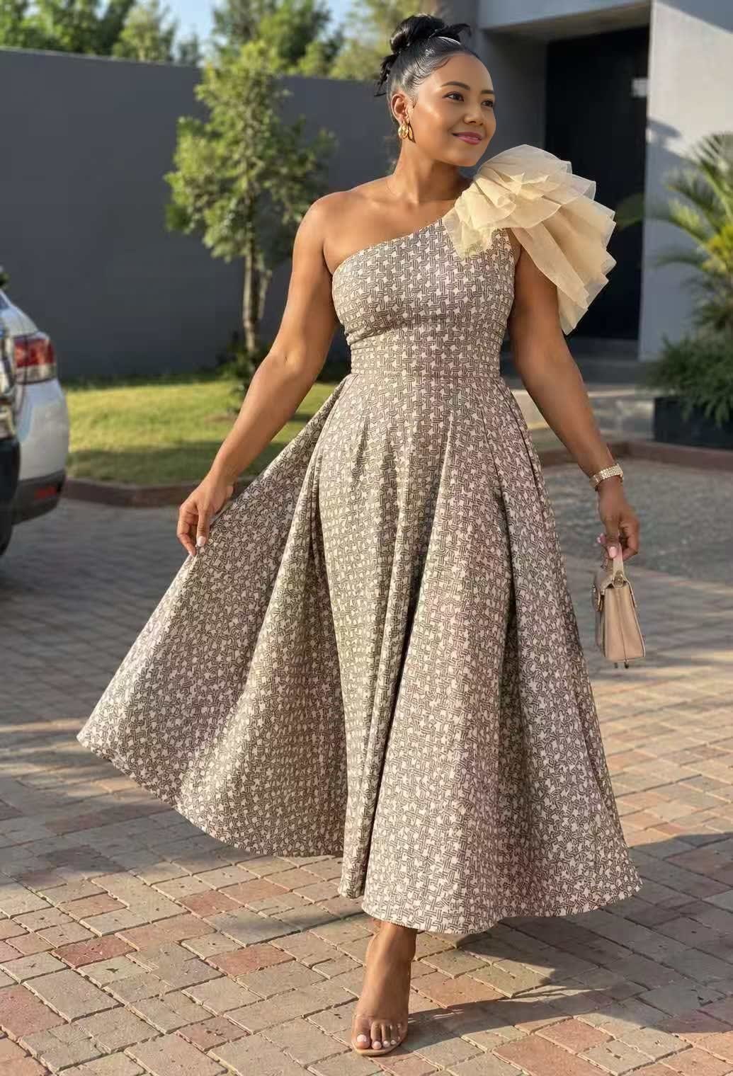 Beige one-shoulder midi dress with geometric print, tulle shoulder ruffle, and pleated skirt
