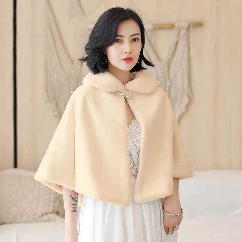 Cream cape with buttoned bow accent at collar, draped poncho style