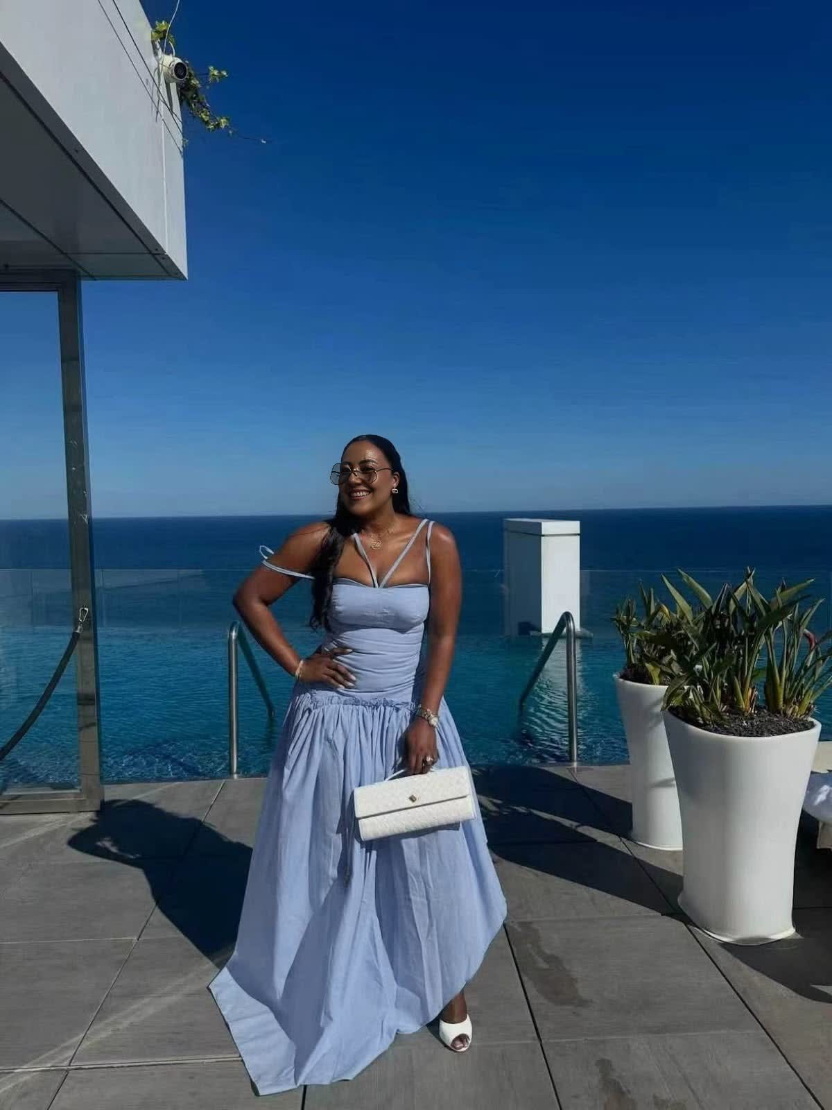 Light blue halter-neck maxi dress with cold shoulders, tie straps, and a gathered waist