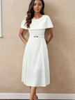 White midi dress with chain neckline, short sleeves, and waist belt