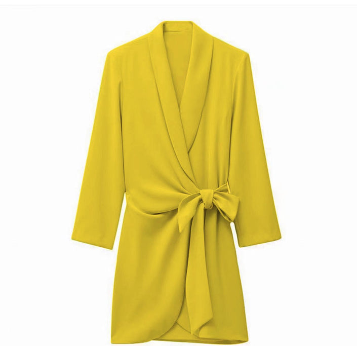 Yellow wrap mini dress with long sleeves, V-neck, and waist tie bow detail.