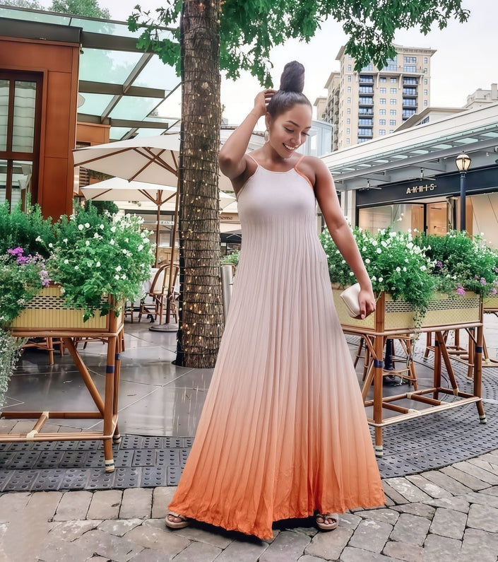 Pleated maxi dress with spaghetti straps, pink-to-peach ombré and flowing A-line skirt.