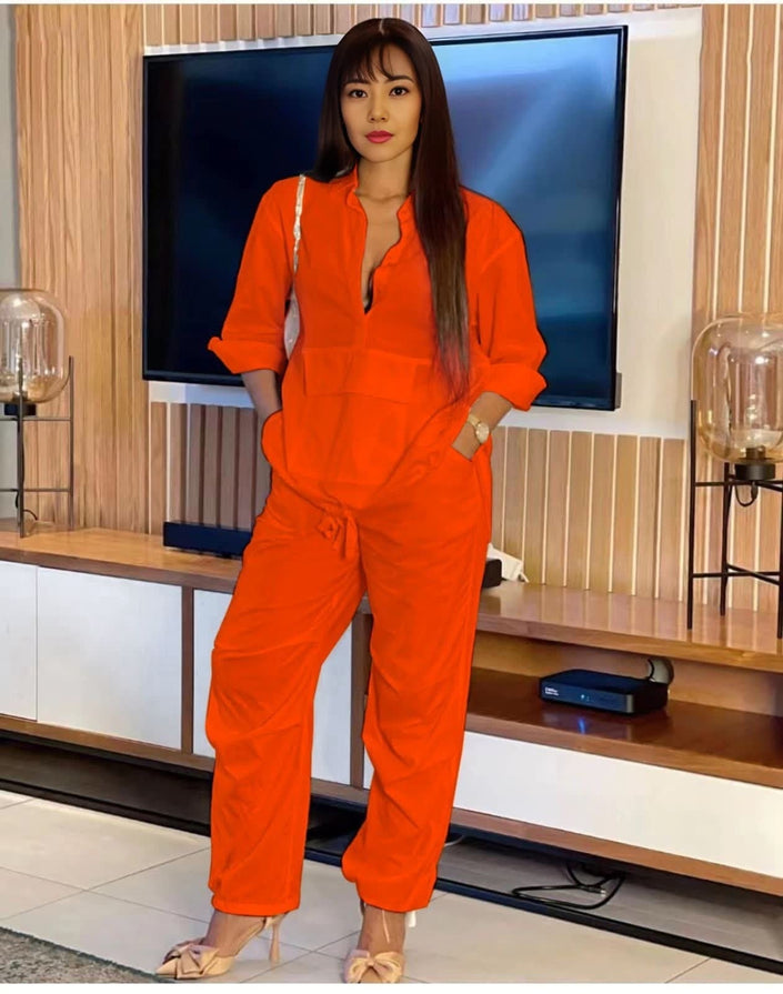 Orange solid color jumpsuit with long sleeves, V-neck, and adjustable waist ties