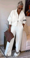 White zip jacket and wide-leg stripe pants with black trim cuffs and hem bands