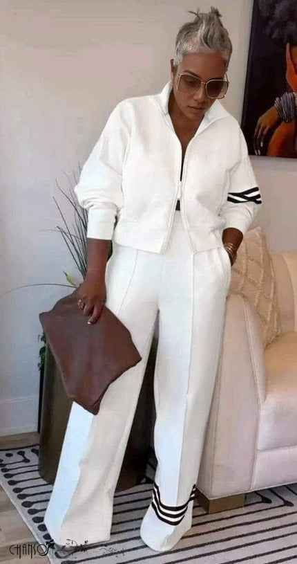 White zip-front jacket with striped cuffs and wide-leg pants, matching set