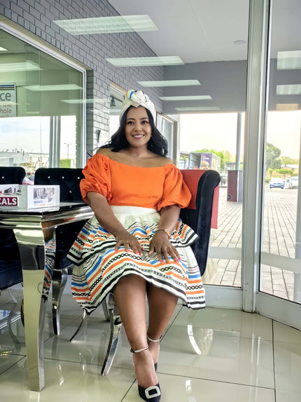 Orange off-shoulder ruffle dress with geometric patterned skirt and wide hem