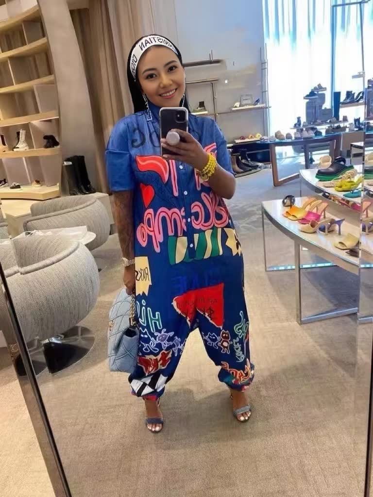 Blue graphic print jumpsuit with short sleeves and wide legs, front opening