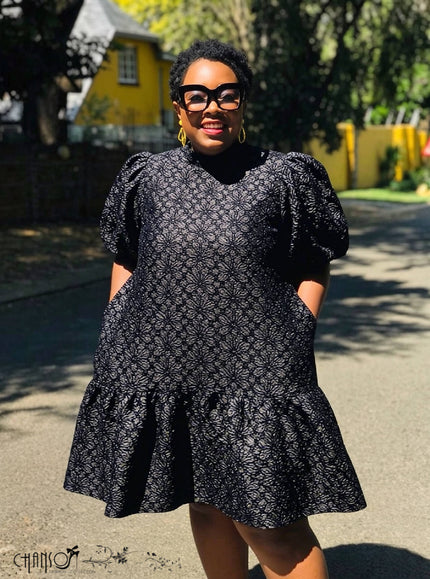 Black lace mini dress with puff sleeves and patterned lace texture