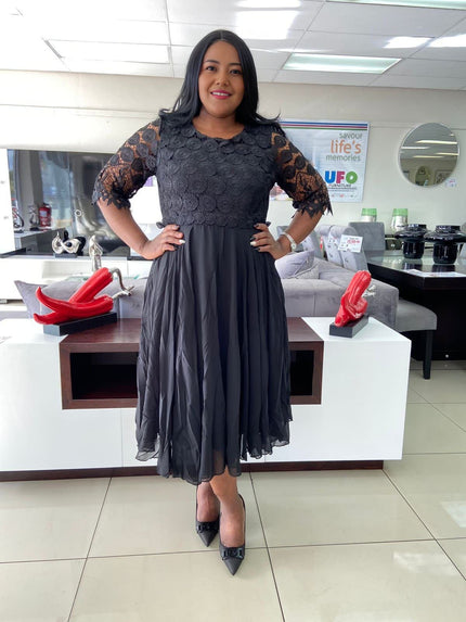 Black lace midi dress with textured bodice, short lace sleeves, and fit-and-flare skirt