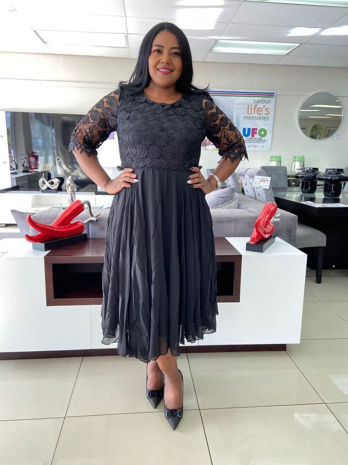 Black lace midi dress with textured bodice, short lace sleeves, and fit-and-flare skirt