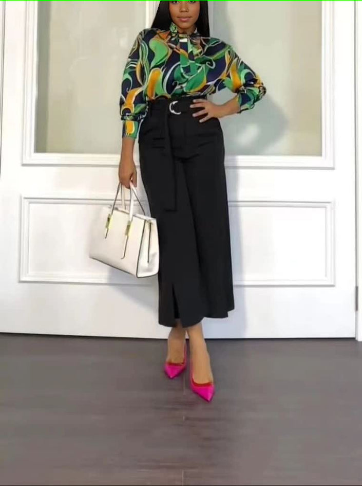 Printed blouse with abstract pattern and black straight trousers