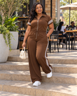 Coffee-brown jumpsuit with zip front, drawstring waist, short sleeves, and white side stripes