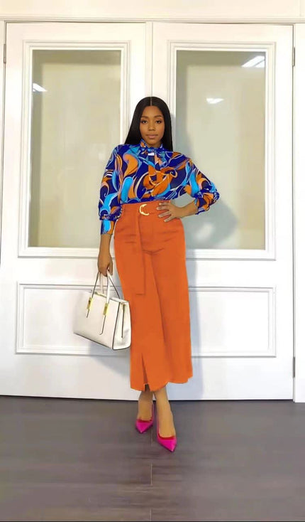 Printed blouse with abstract pattern and orange straight trousers