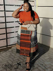 Geometric stripe print dress, orange-red crewneck bodice and patterned skirt with contrast trim