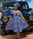 Purple one-shoulder ruffle dress with circular print and flared skirt