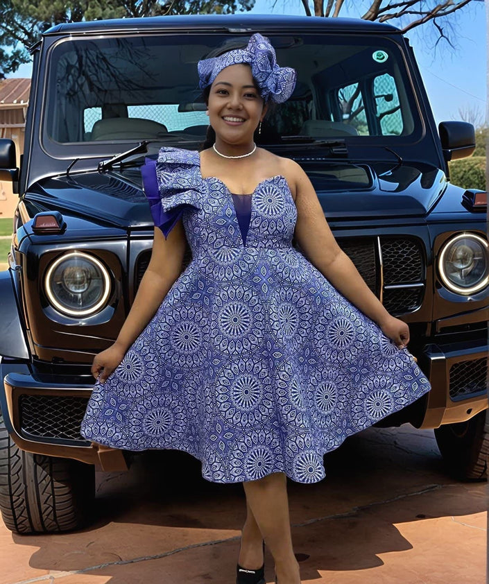 Purple one-shoulder ruffle dress with circular print and flared skirt