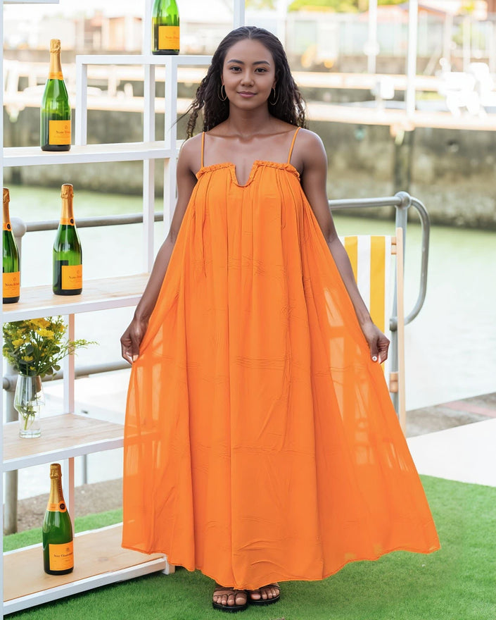Orange maxi dress with adjustable spaghetti straps, gathered bust and flowy skirt.