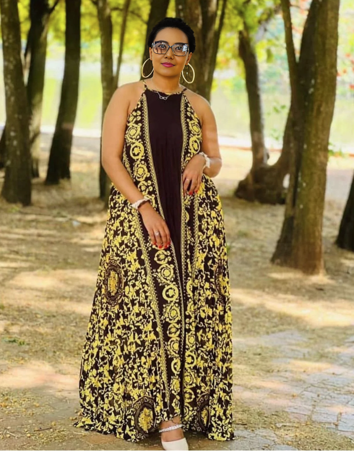 Sleeveless maxi dress with bold black-and-yellow African print, halter neckline