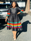Dark midi dress with long sleeves, gathered skirt, and multicolor striped hem