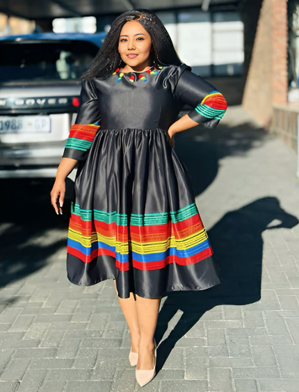 Dark midi dress with long sleeves, gathered skirt, and multicolor striped hem