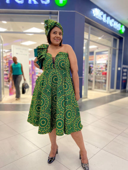 One-shoulder ruffle dress in dark green with circular African print, flared skirt