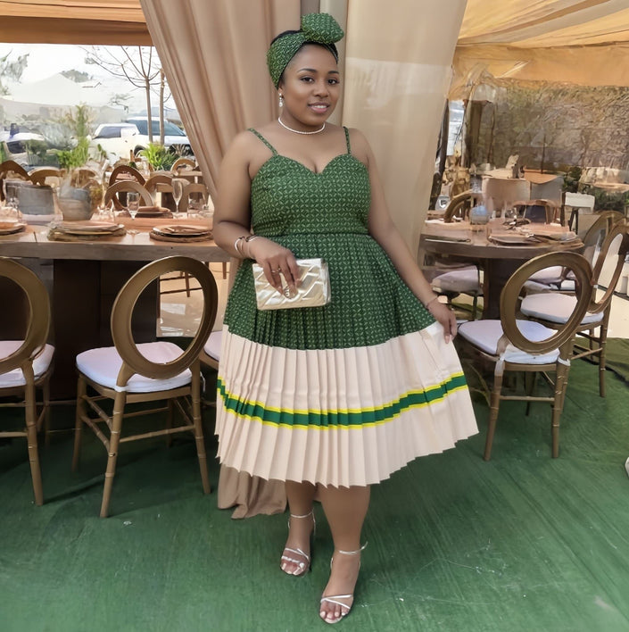 Pleated midi dress with thin straps, green bodice, cream pleated skirt and striped hem